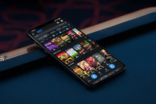 A young woman relaxing with her phone while dynamic casino elements float around her, illustrating the smooth mobile experience offered by the JL66 app.