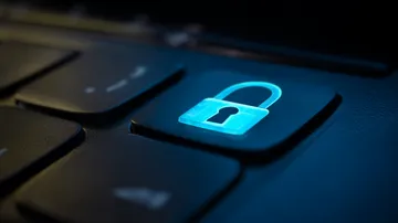 A laptop glowing with a bright login prompt in a minimalistic setup, symbolizing the protected access system at JL66.